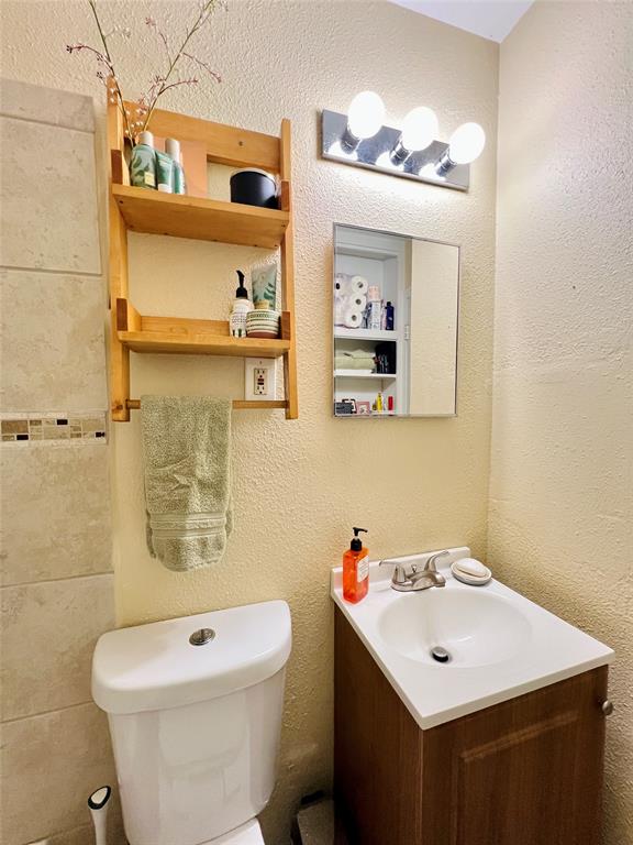 310 West 15th Street Irving, TX 75060 - Photo 18 of 30 a bathroom with a sink a toilet and mirror