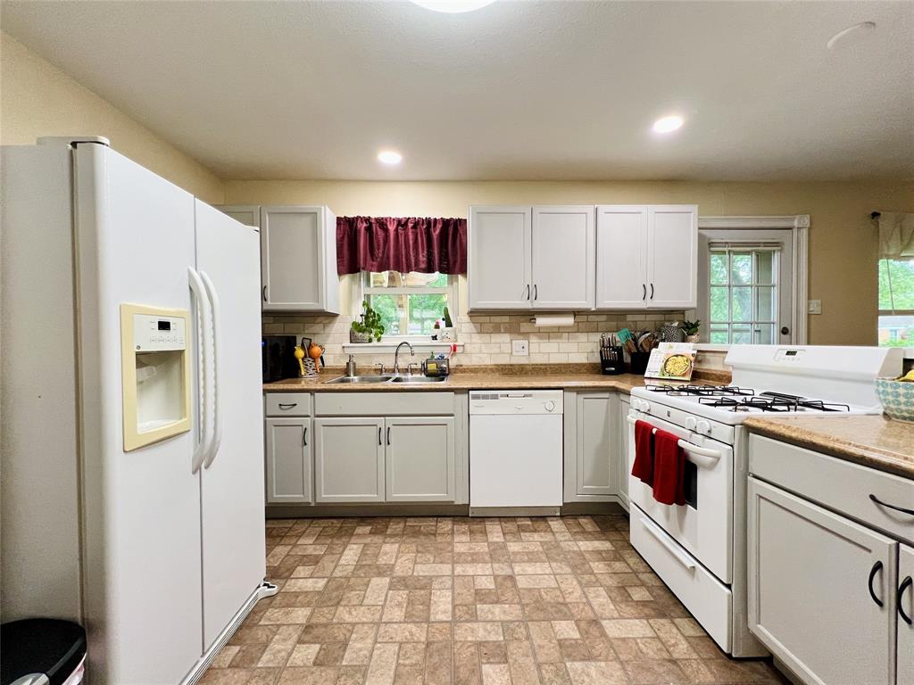 310 West 15th Street Irving, TX 75060 - Photo 22 of 30 a kitchen with stainless steel appliances granite countertop a stove a sink and a refrigerator
