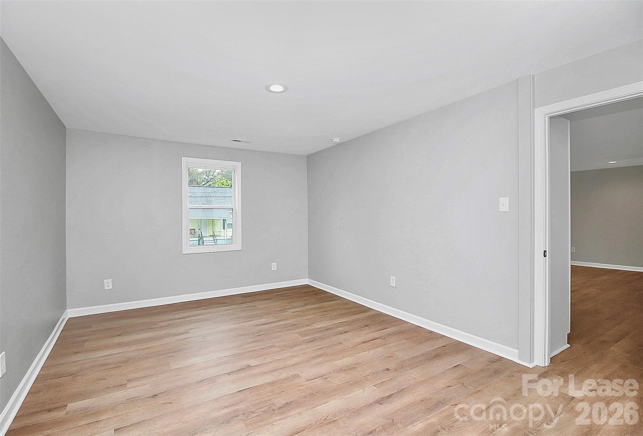 315 South Ransom Street Gastonia, NC 28052 - Photo 4 of 18 an empty room with wooden floor and windows