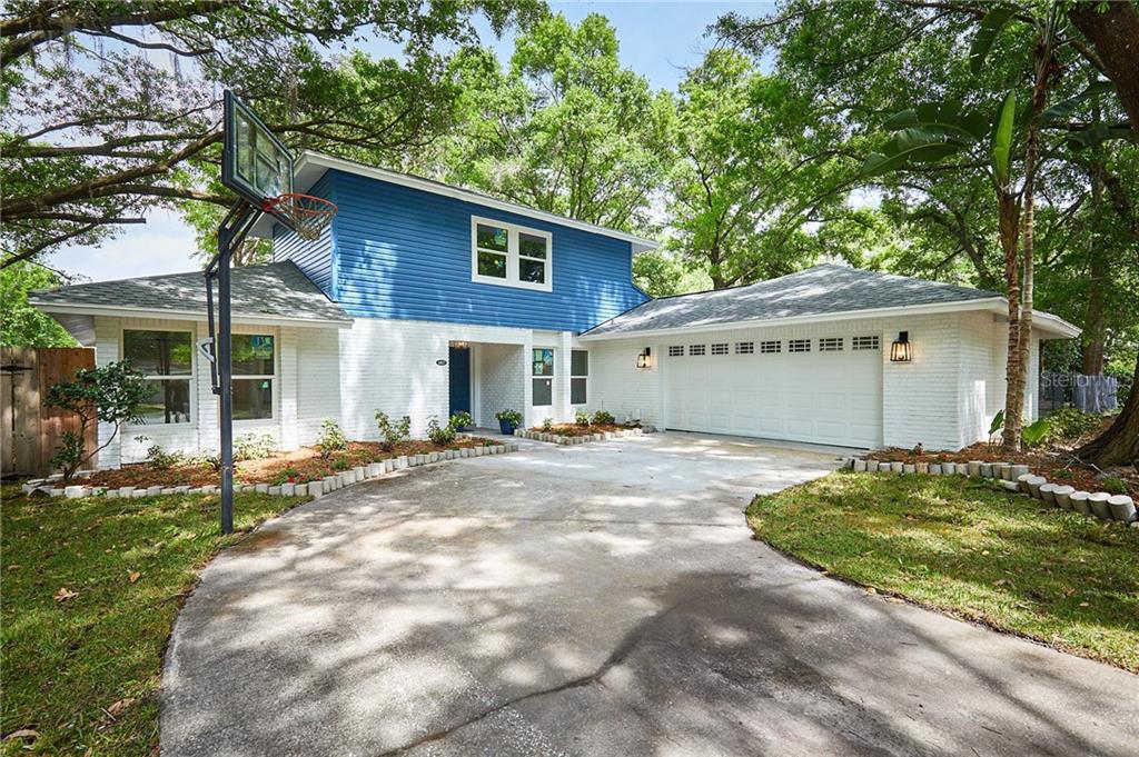 a view of a house with backyard and a tree