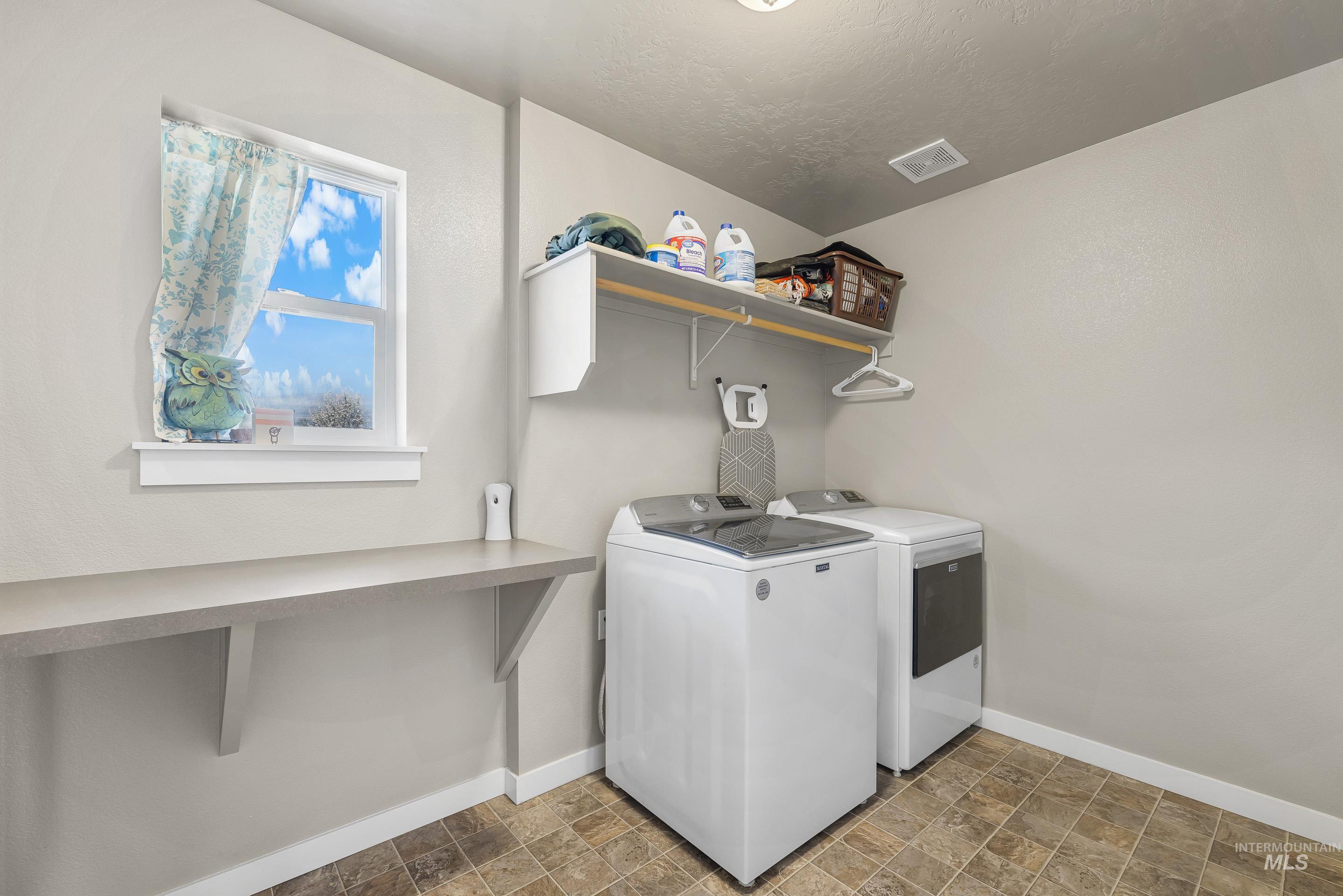 700 Southwest Panner Street Mountain Home, ID 83647 - Photo 22 of 50 Laundry room with stone finish floors and washing machine and clothes dryer