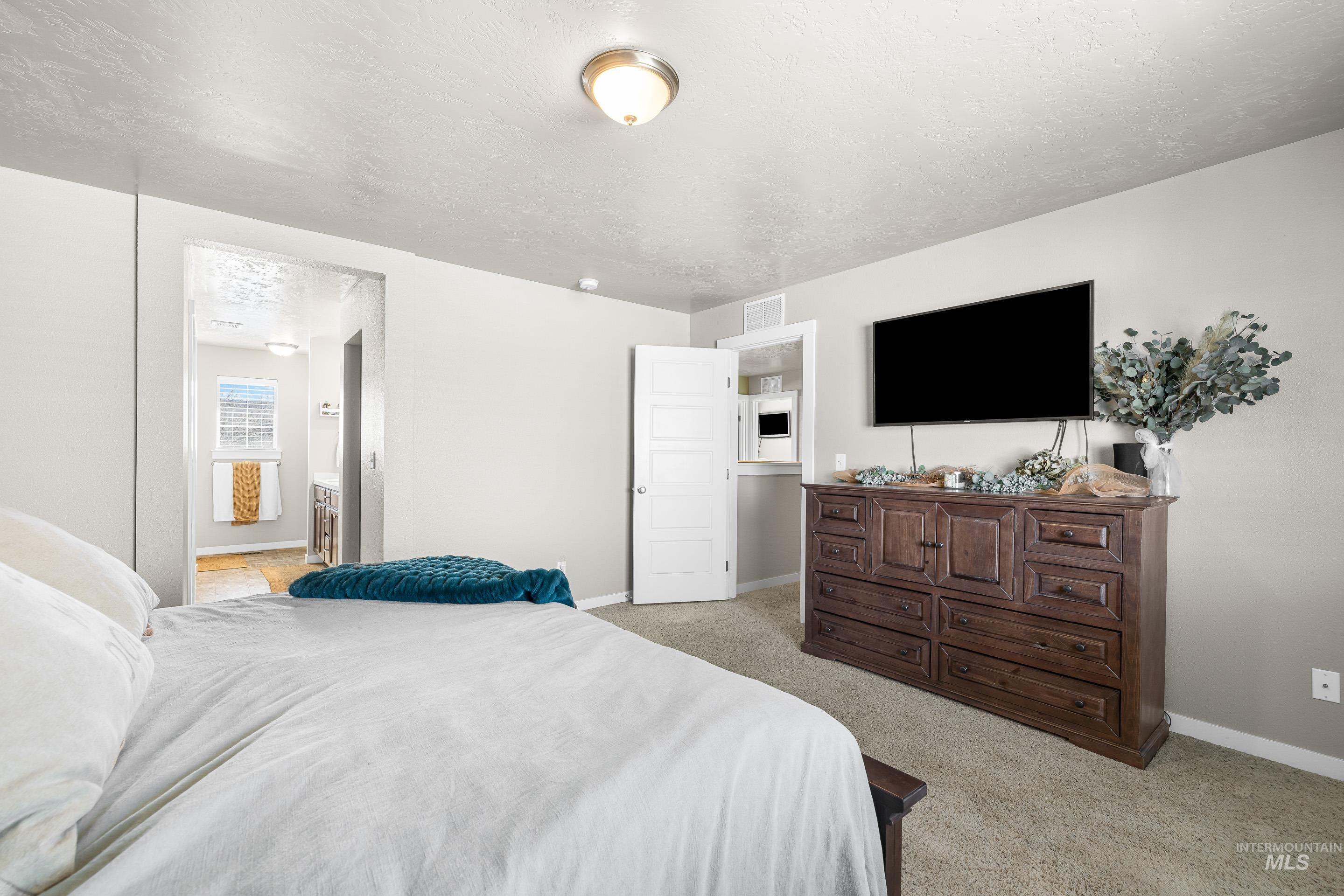 700 Southwest Panner Street Mountain Home, ID 83647 - Photo 30 of 50 Bedroom featuring light carpet and ensuite bathroom