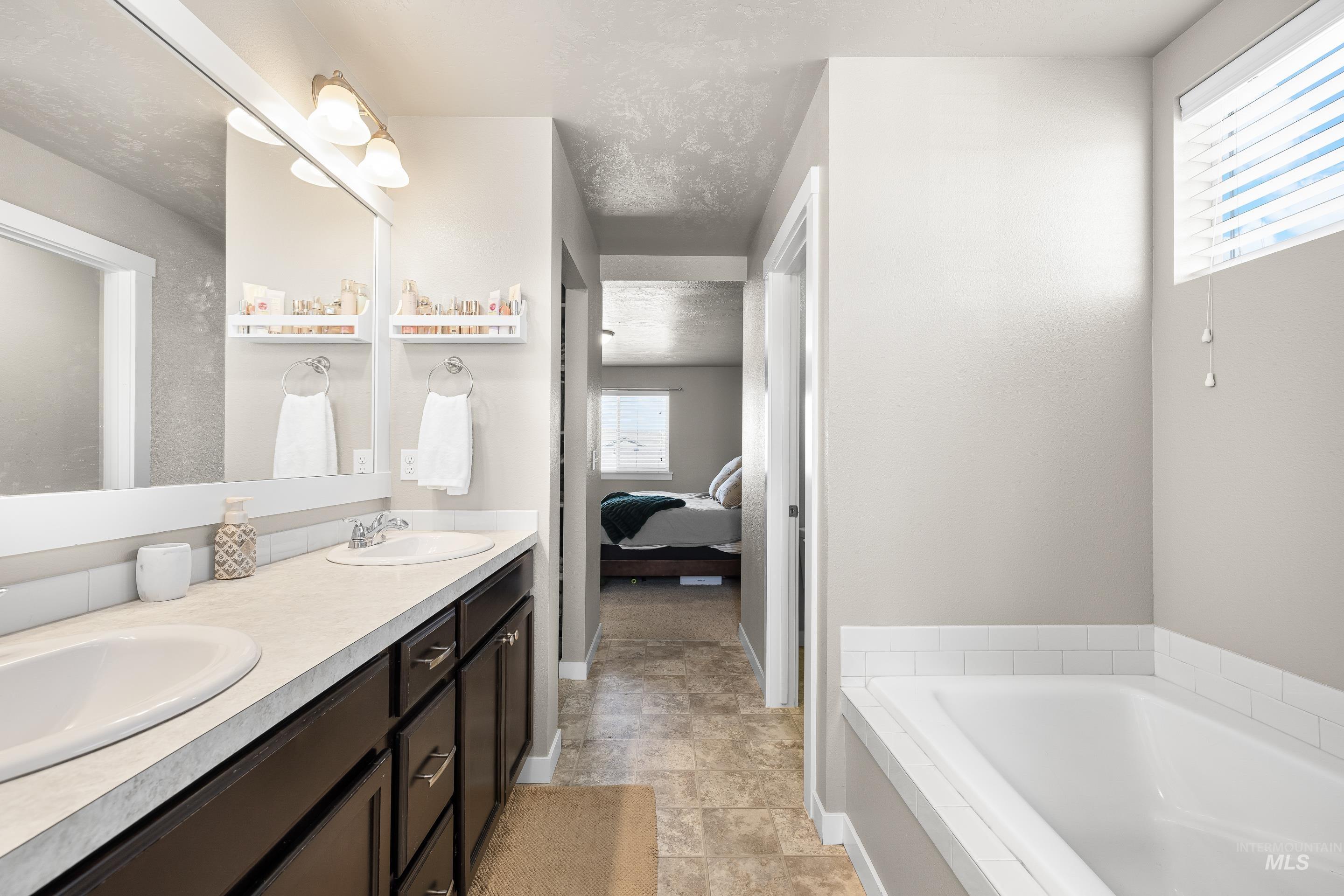 700 Southwest Panner Street Mountain Home, ID 83647 - Photo 34 of 50 Full bathroom with double vanity, a bath, and ensuite bathroom