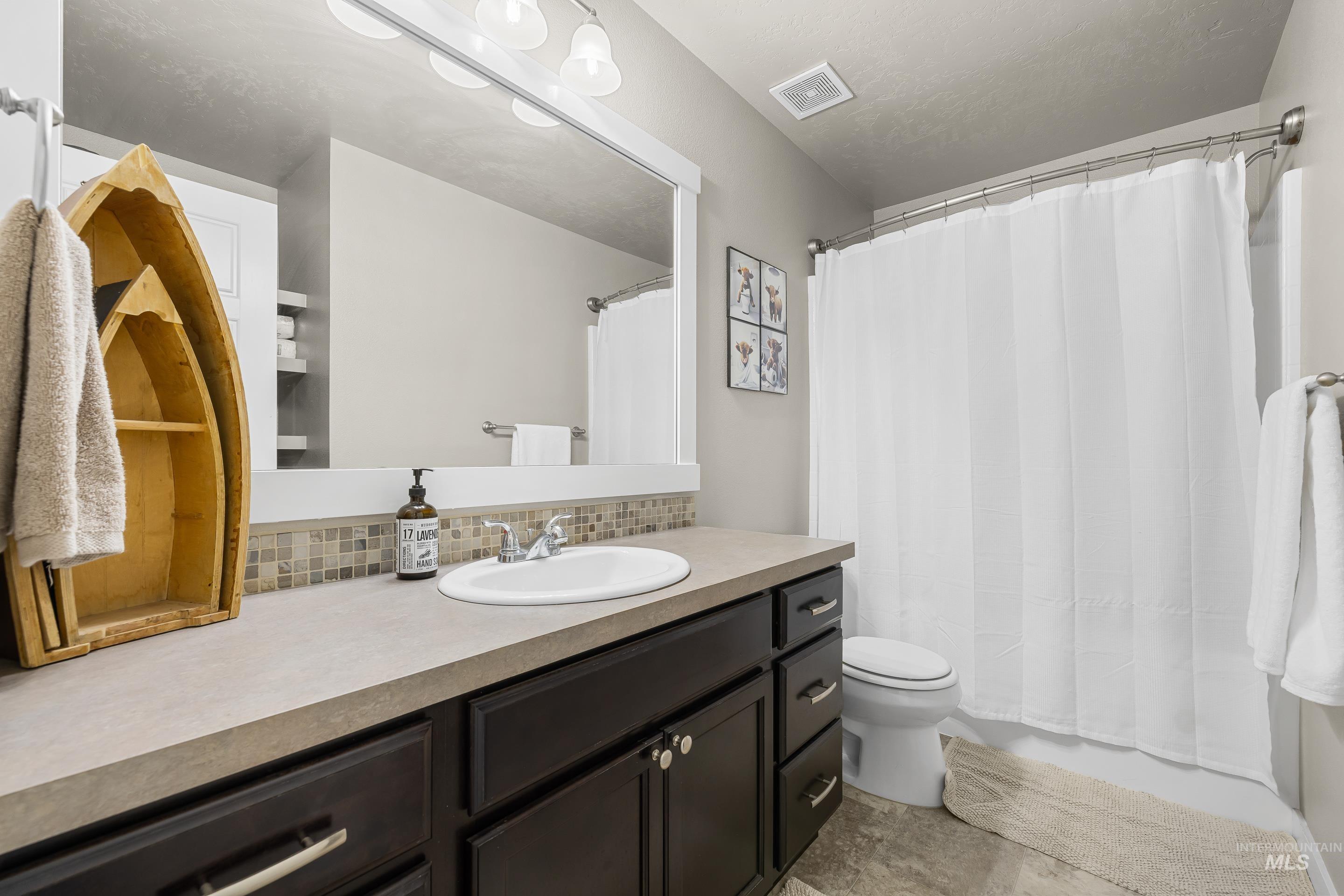 700 Southwest Panner Street Mountain Home, ID 83647 - Photo 39 of 50 Bathroom featuring vanity and decorative backsplash
