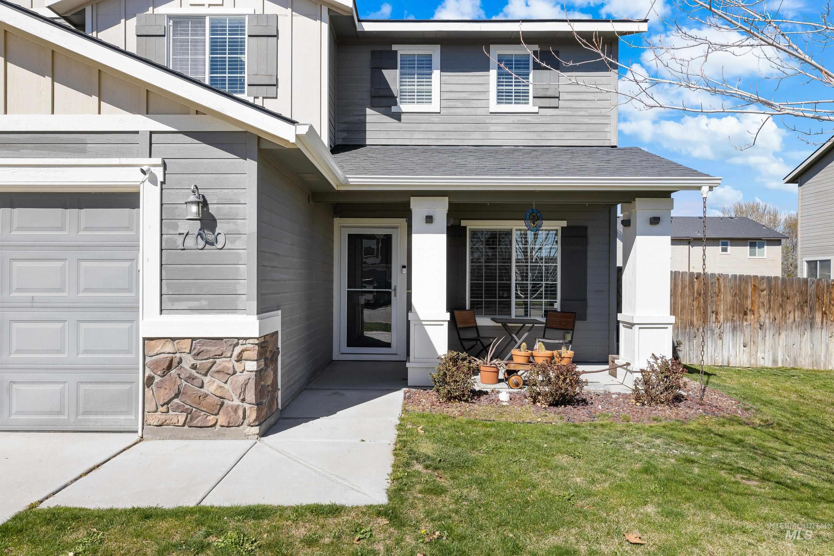 700 Southwest Panner Street Mountain Home, ID 83647 - Photo 4 of 50 Doorway to property featuring a porch, stone siding, roof with shingles, and board and batten siding