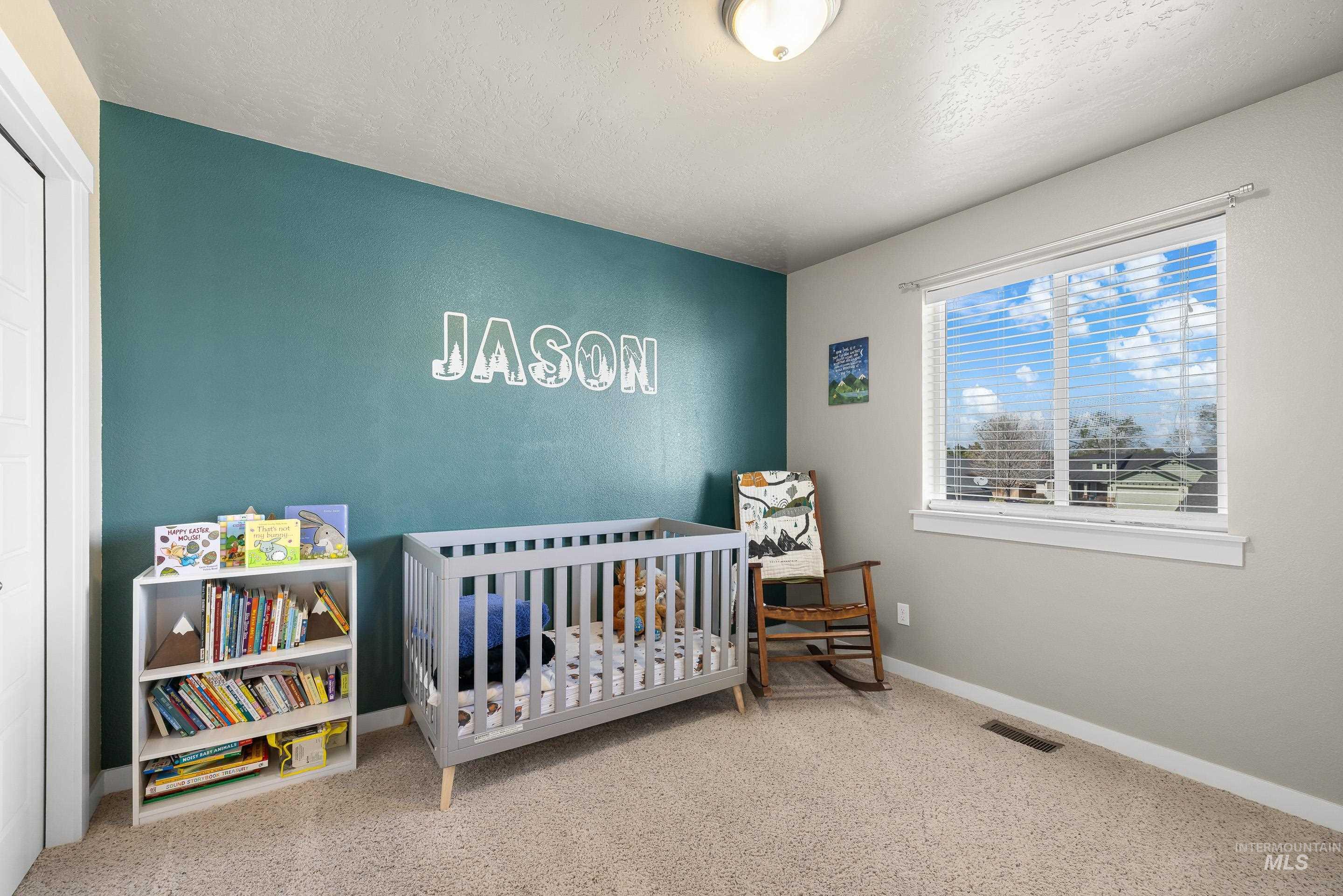 700 Southwest Panner Street Mountain Home, ID 83647 - Photo 44 of 50 Bedroom with a nursery area, light carpet, and a textured ceiling