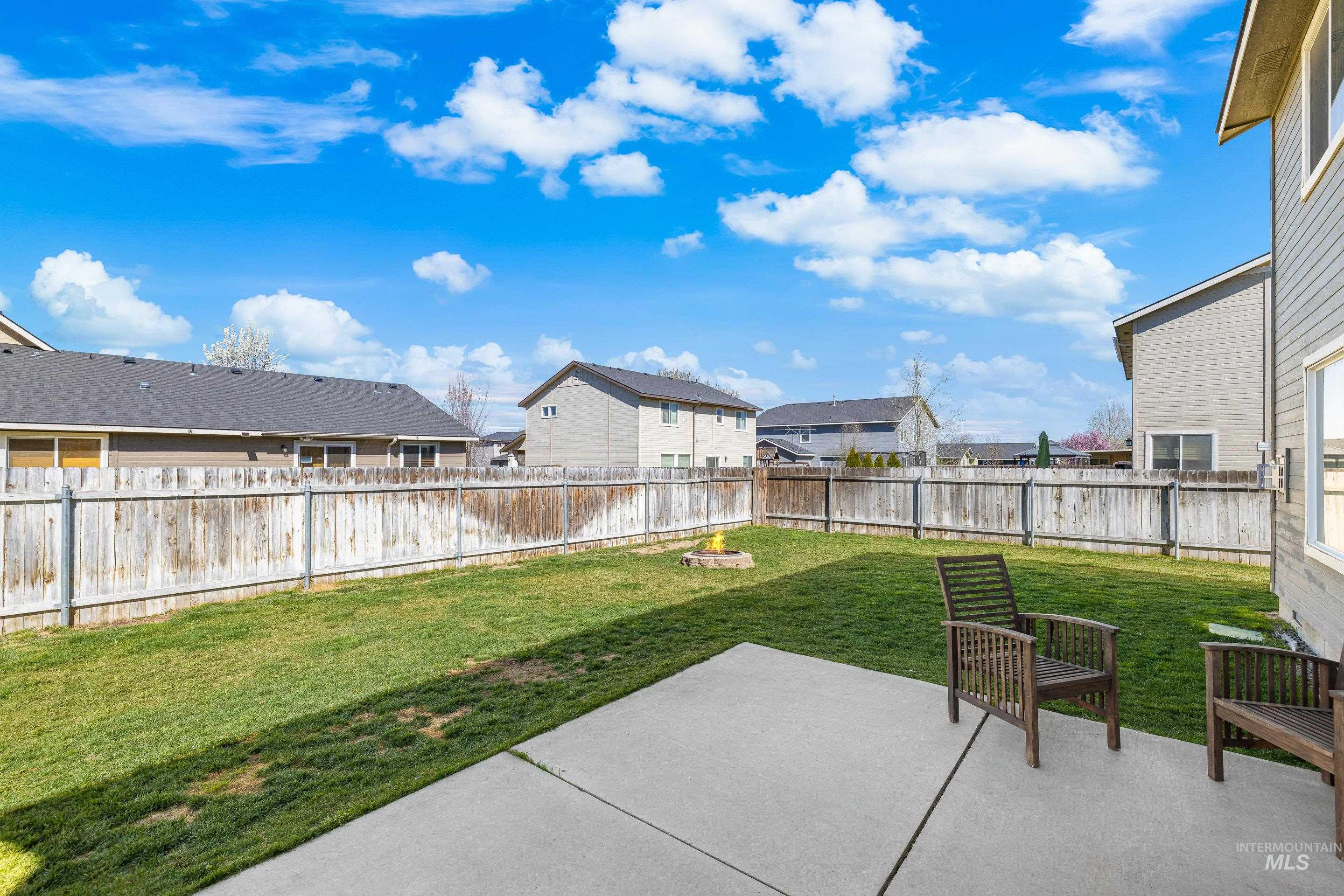 700 Southwest Panner Street Mountain Home, ID 83647 - Photo 45 of 50 Fenced backyard featuring a residential view, a patio area, and a fire pit