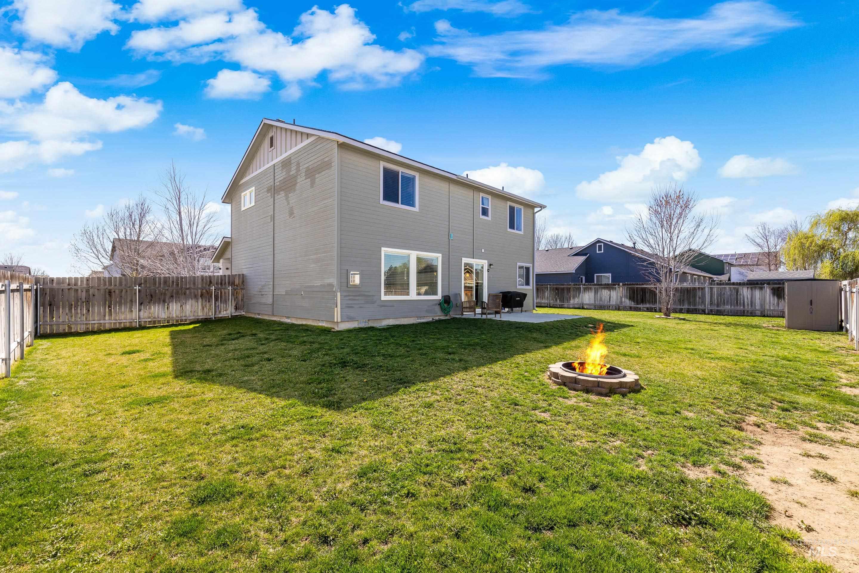 700 Southwest Panner Street Mountain Home, ID 83647 - Photo 47 of 50 Rear view of house with an outdoor fire pit, a patio, a storage shed, and a fenced backyard