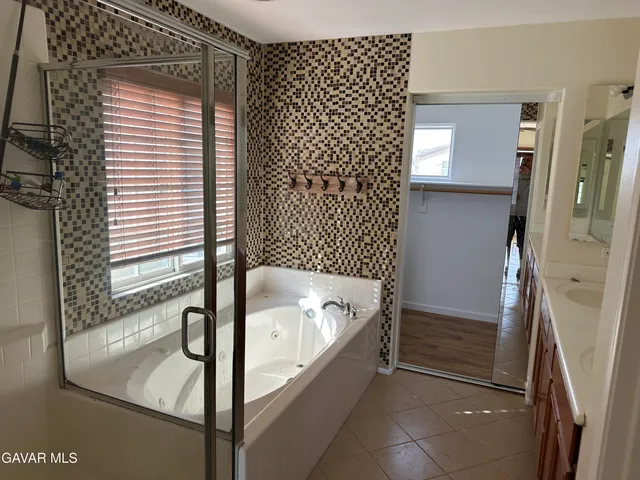 a bathroom with a tub sink and shower