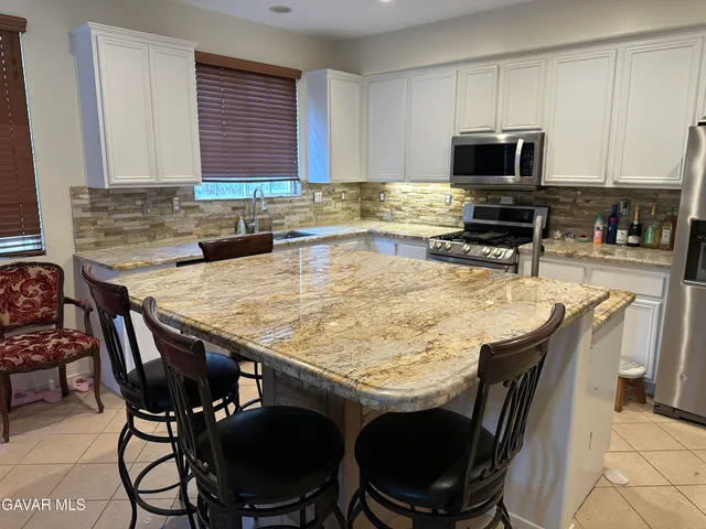 a kitchen with a stove a sink a microwave and dining table