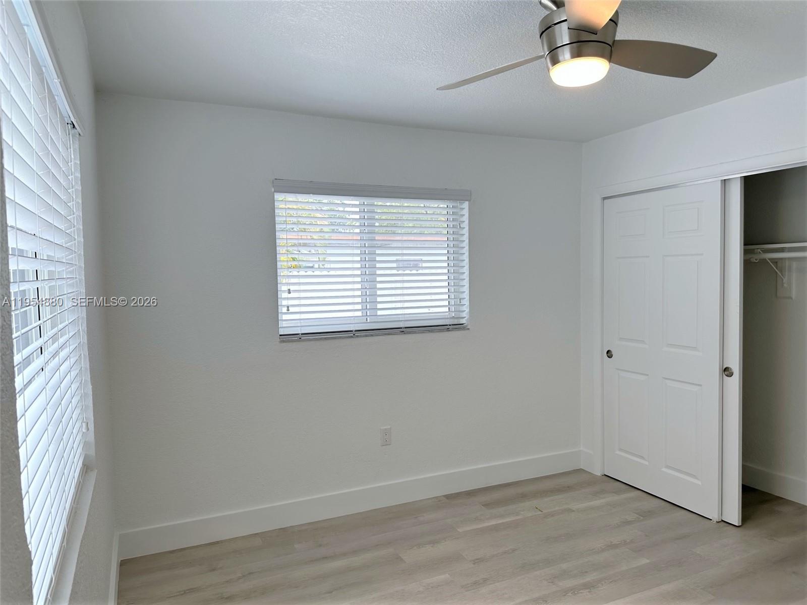 11230 Southwest 5th Street, Unit 1 Sweetwater, FL 33174 - Photo 11 of 25 an empty room with a window and a fan