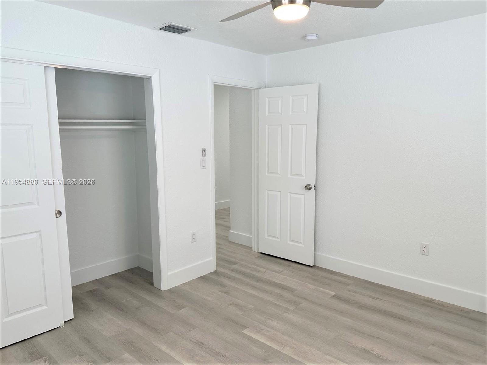 11230 Southwest 5th Street, Unit 1 Sweetwater, FL 33174 - Photo 12 of 25 an empty room with wooden floor and closet area