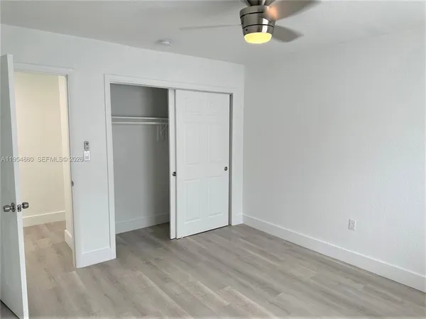 a view of empty room with window and wooden floor