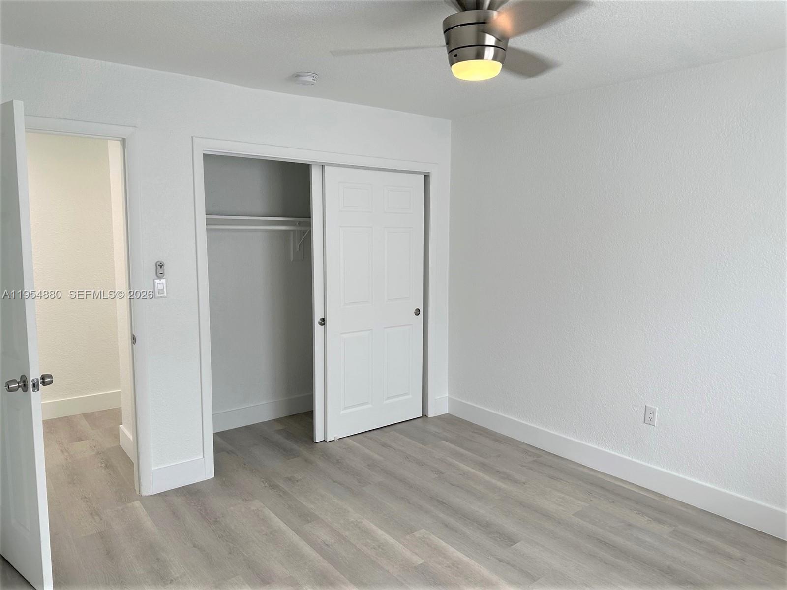 11230 Southwest 5th Street, Unit 1 Sweetwater, FL 33174 - Photo 16 of 25 a view of empty room with window and wooden floor