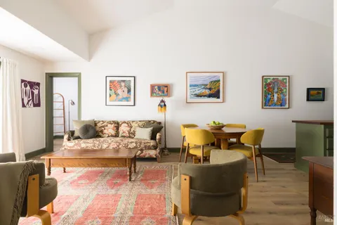 a living room with furniture and painting on the wall