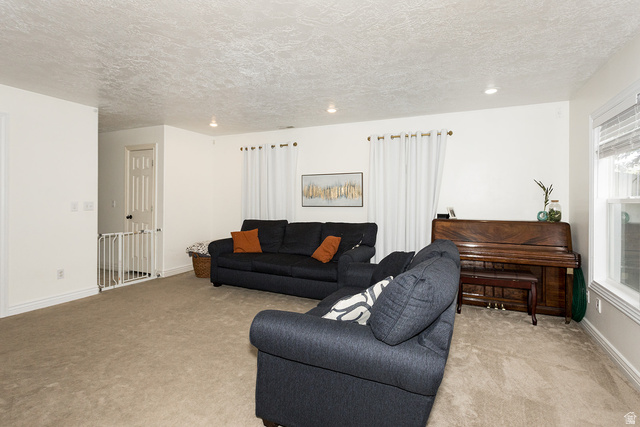 7797 North Windhover Road Eagle Mountain, UT 84005 - Photo 8 of 33 Carpeted living area featuring white walls, recessed lighting, and a prominent window with blinds
