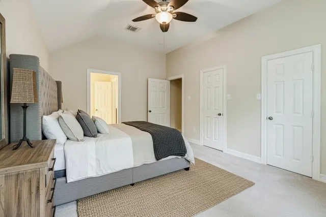 a bedroom with a large bed and ceiling fan