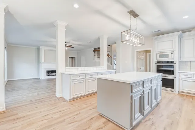 a kitchen with stainless steel appliances granite countertop a refrigerator a stove a sink dishwasher and a refrigerator with wooden floor