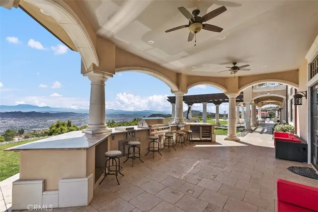 a living room with stainless steel appliances furniture a rug kitchen view and a table