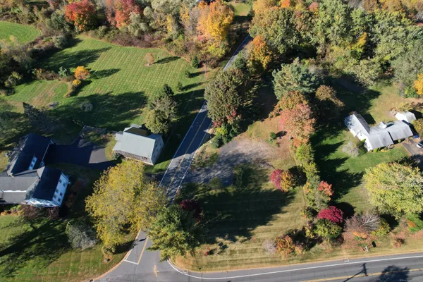 an aerial view of residential house with outdoor space and trees all around