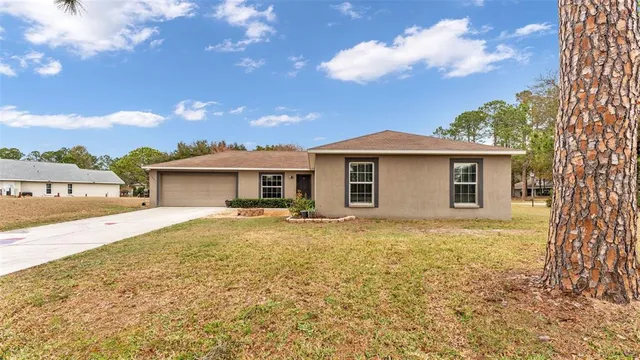 a front view of a house with a garden and yard