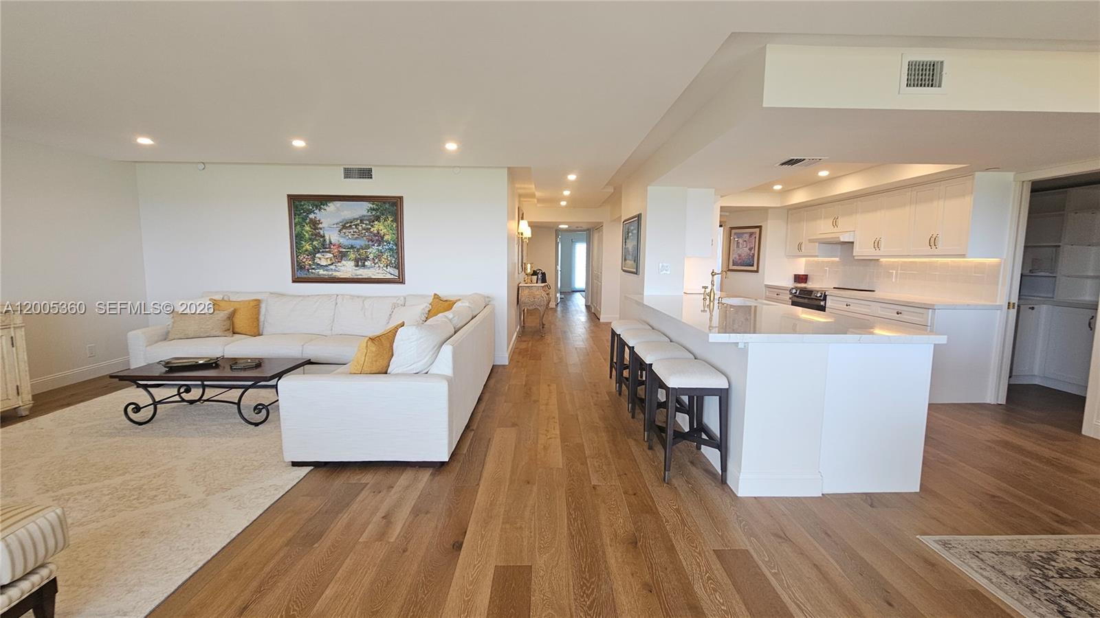 4001 North Ocean Boulevard, Unit 702 Boca Raton, FL 33431 - Photo 15 of 56 a living room with couches and kitchen view with wooden floor