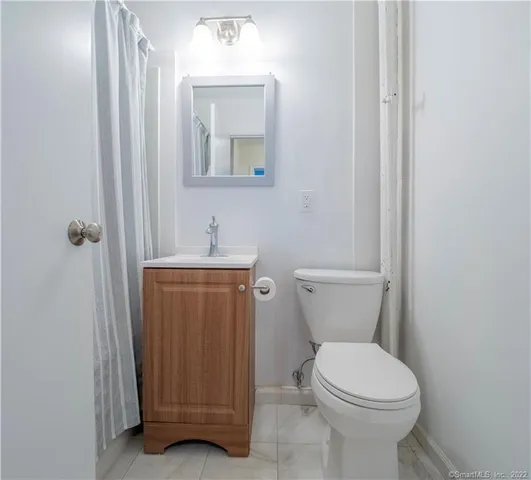 a bathroom with a toilet a sink and mirror