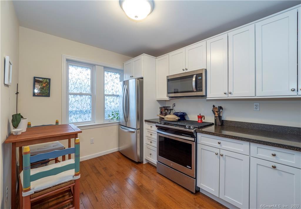 115 Main Street, Unit 5 Norwalk, CT 06851 - Photo 6 of 23 a kitchen with granite countertop a stove top oven microwave and cabinets