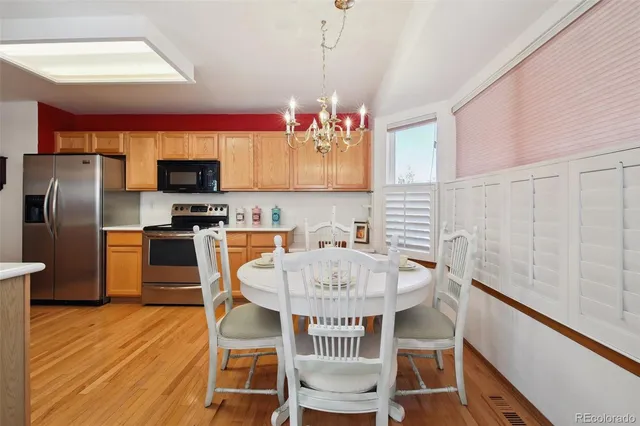a kitchen with kitchen island a dining table chairs stainless steel appliances and cabinets