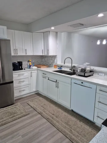 a kitchen with white cabinets stainless steel appliances and sink
