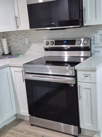a stove top oven sitting inside of a kitchen