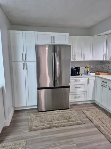 a kitchen with a refrigerator sink and cabinets
