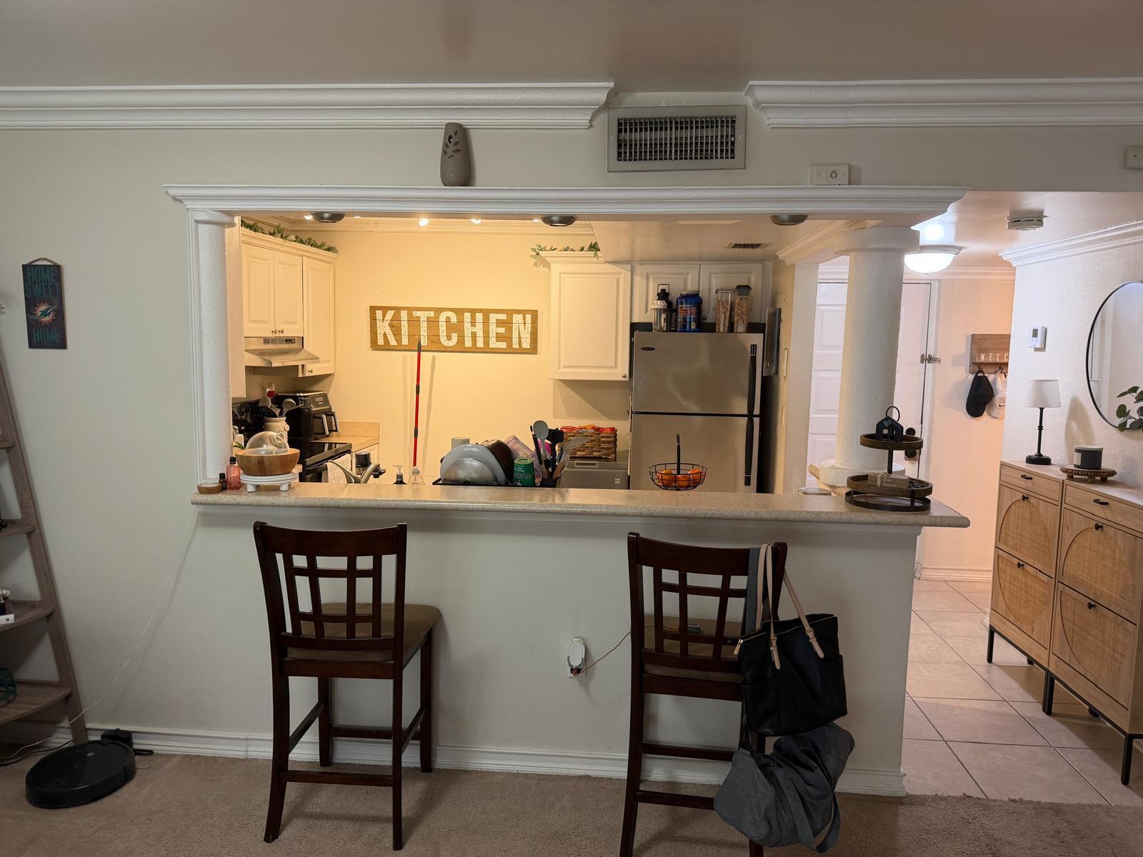 711 North Pine Island Road, Unit 104 Plantation, FL 33324 - Photo 4 of 9 a kitchen with a table chairs and a refrigerator