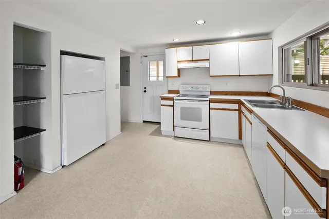 a kitchen with white cabinets and white appliances