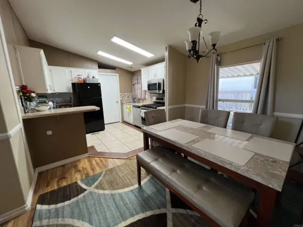 a kitchen with a table chairs refrigerator and microwave