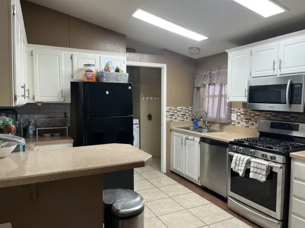 a kitchen with stainless steel appliances a sink a stove a refrigerator and cabinets