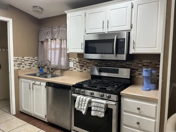 a kitchen with cabinets appliances and a sink