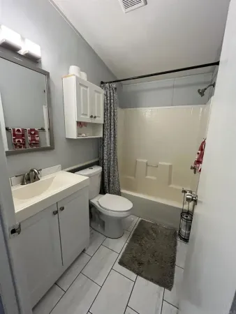 a bathroom with a granite countertop sink mirror vanity and toilet