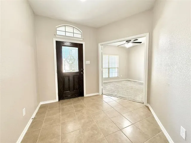 an empty room with mirror and windows