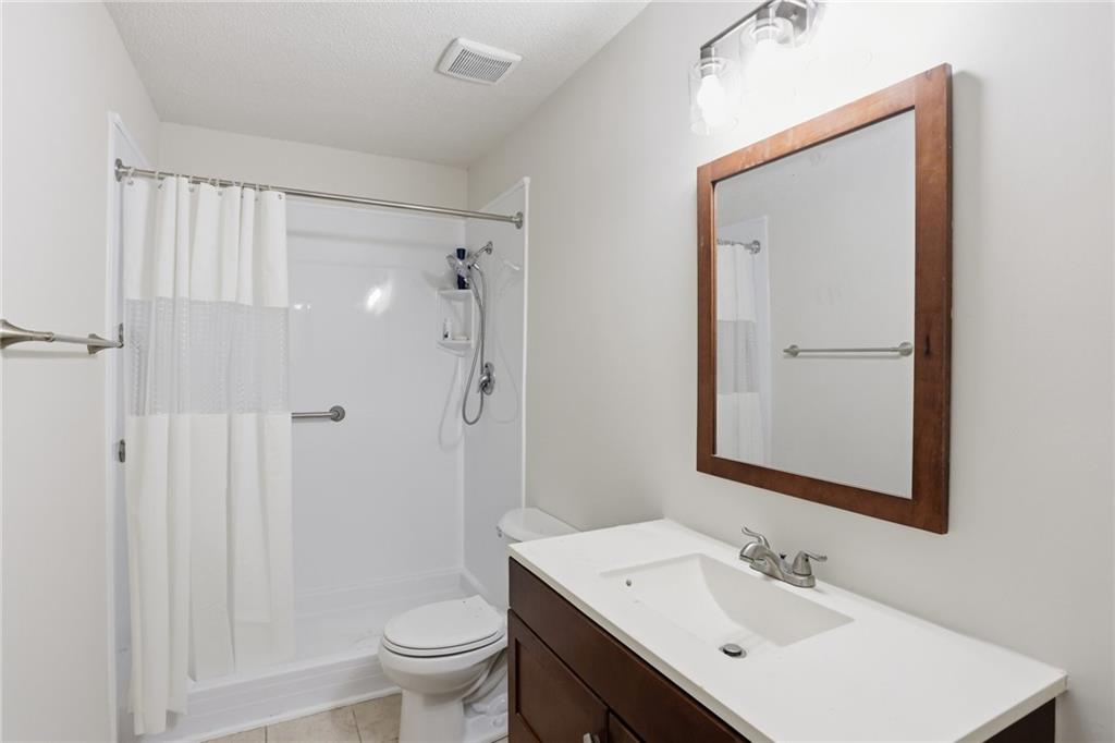 413 Promenade Court Marietta, GA 30064 - Photo 20 of 28 a bathroom with a sink a toilet and shower a mirror
