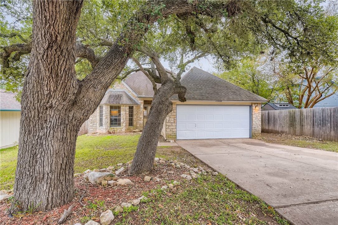 a front view of a house with a garden and trees