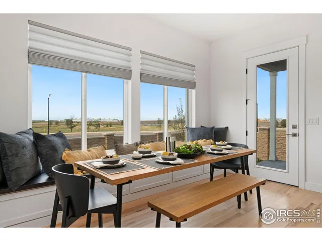 a dining room with furniture and a floor to ceiling window