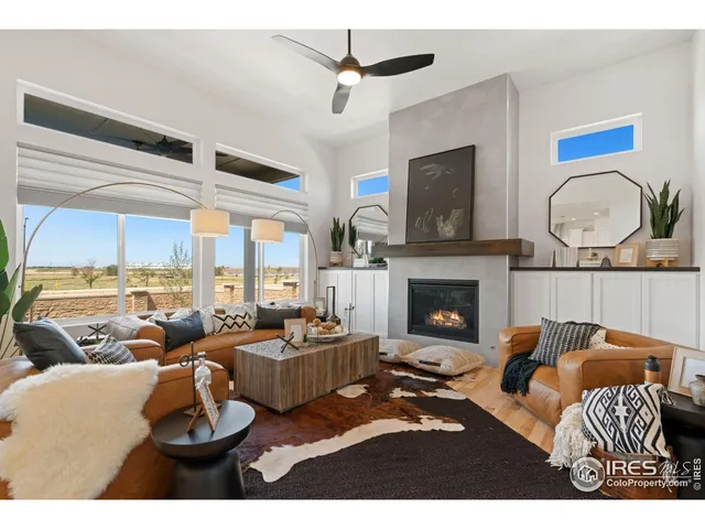 a living room with furniture a fireplace and a large window