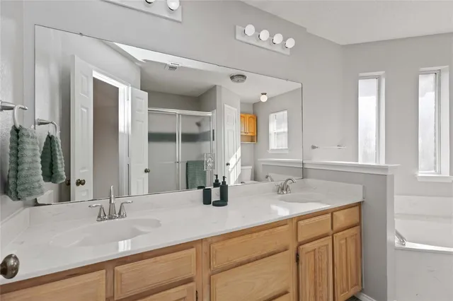 a bathroom with double vanity sinks and a mirror
