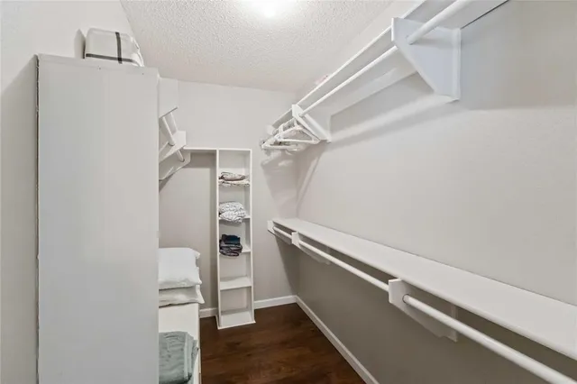 a view of walk in closet with clothes and shoes