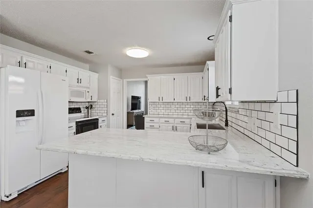 a kitchen with refrigerator and white cabinets