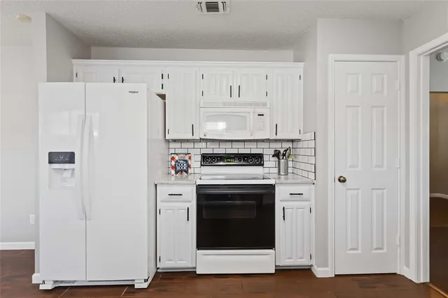a kitchen with cabinets and white stainless steel appliances