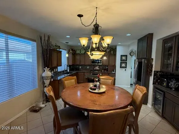 a kitchen with granite countertop a table chairs microwave and refrigerator