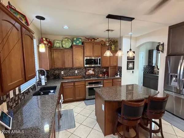a kitchen with stainless steel appliances granite countertop a refrigerator and a sink