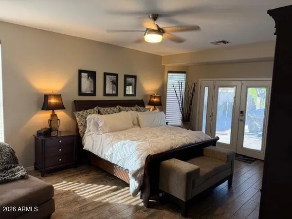 a bedroom with a bed and wooden floor
